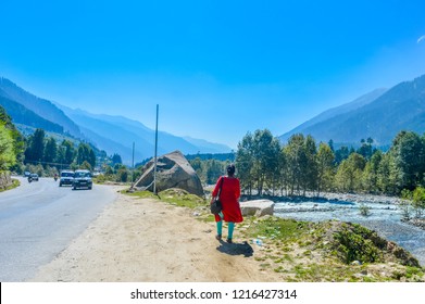 A lady in red drees walking on  highway road in blue sky mountain background. panorama  landscape 
 view Himalayan valley of 