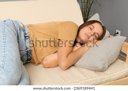 Lady resting. Boredom relief. Sleepy girl. Health break. Comfy sofa rest. Daytime calm. Caucasian woman lying on sofa in living room sleeping in home interior.