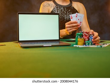 A Lady In A Smart Dress Plays Poker Online. She Has Playing Cards In Her Hand. Colored Cards Lie Near The Laptop. Hope For A Win, A Good Bet. Free Time. Gambling Business. Gambling Addiction.