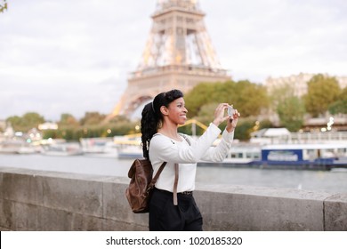 Lady Standing On Embankment Not Far From Eiffel Tower In Paris And Watching Pictures Of Landmarks Made During Day On Mobile. Girl Came To France To Visit Pen Pal And Decided To Go On City Tour. Pretty