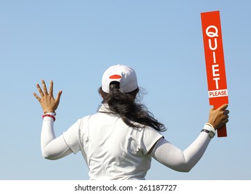 The lady volunteer shows the quite please sign before starting game in golf tournament.