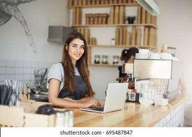 lady waiting for a customer coffee order, starting a day on her dream job. - Powered by Shutterstock