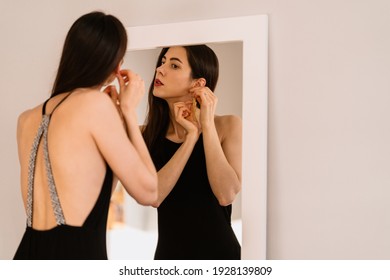 Lady wears beautiful black dress looking into the mirror