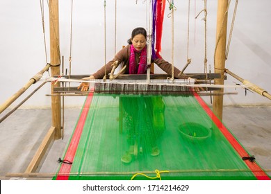 Lady weaving silk cloth Mekhela (traditional Assamese dress) on wooden hand operated machine called loom at Kaziranga Orchid Park on 24/01/2020. A loom is a device used to weave cloth and tapestry. 