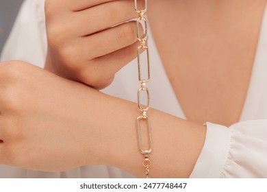 Lady in white outfit shows elegant jewelry, bracelet. Product image with women's jewelry concept.