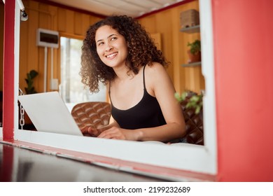 Lady Working On A Laptop While Looking Out The Window Of Her Modern, Trendy And Edgy House. Smiling, Positive And Young Female Student With An Afro Browsing On Technology While Thinking And Learning