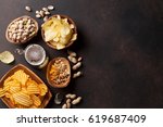 Lager beer and snacks on stone table. Nuts, chips. Top view with copyspace