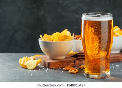 Lager beer and snacks on stone table. Cracker, chips side view - Powered by Shutterstock