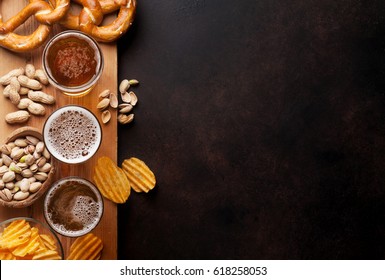 Lager beer and snacks on stone table. Nuts, chips, pretzel. Top view with copy space