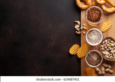 Lager beer and snacks on stone table. Nuts, chips, pretzel. Top view with copy space