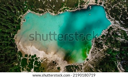 Lago di Sorapiss from above,beautiful mountain lake in Dolomite Alps,Italy.Turquoise color water is dust from the glacier.crystal clear water top down view.Drone nature, alpine forest