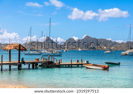 Lagoon with turquoise waters, yachts and boats at Mayreau island pier with Union island in the background, Saint Vincent and the Grenadines, West Indies, Caribbean