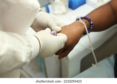 Lagos Nigeria West Africa-October 5 2022: A Hand Trying To Use Syringe In A Hospital With Gloves And Waist Bead In The Hand