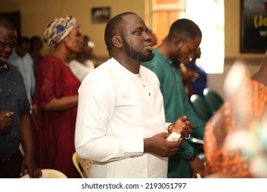 Lagos, Nigeria-August 21, 2022: A Nigerian Man Praying Among Crowd In The Church