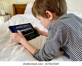 Lagos, Portugal 04 Jan 2022; Young boy lying on a bed and playing Minecraft on an iPad