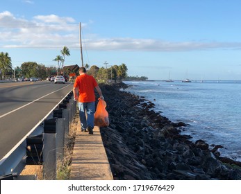 LAHAINA, HAWAII, USA - MARCH 19, 2019: Highway Clean Up Volunteer Looking For Trash To Pick Up Next To The Beach In Lahaina, Maui.