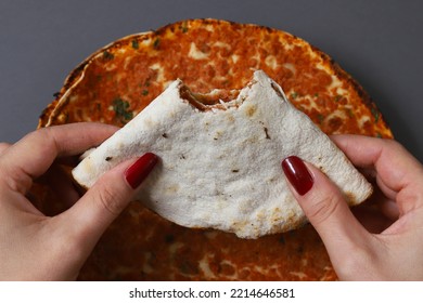 Lahmajoun - A Minced Meat Dish On A Flatbread. Bitten Cake With Minced Meat In Female Hands. Shallow Depth Of Field	