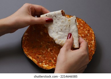 Lahmajoun - A Minced Meat Dish On A Flatbread. Bitten Cake With Minced Meat In Female Hands. Shallow Depth Of Field	