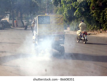 LAHORE, PAKISTAN - OCT 13: Auto-rickshaw Emits Smoke Passes Through A Road Violates Traffic Laws Showing The Negligence Of Traffic Police Department On October 13, 2011in Lahore, Pakistan.