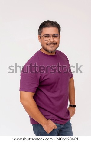 A laid back likable stocky man wearing glasses hands inside the pockets of his jeans. Half body photo, quarter turn isolated on a white background.