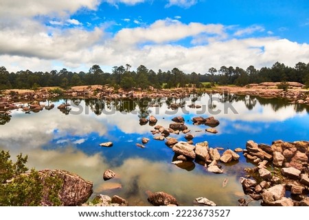 lake in abeautiful day with rocks on the water, clouds in the sky and pine trees in the background, mexiquillo durango, sierra madre occidental 