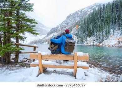 Lake Agnes by Lake Louise Banff National Park with snowy mountains in the Canadian Rocky Mountains during winter. A couple of men and women sitting on a bench by the emerald green lake in Canada with - Powered by Shutterstock