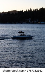 Lake Arrowhead, California - August 8 2019: At Dusk, The Silhouette Of A Boat Goes To Shore.