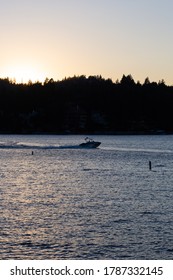 Lake Arrowhead, California - August 8 2019: A Boat Speeds Across The Lake During Sunset. Vertical Shot.