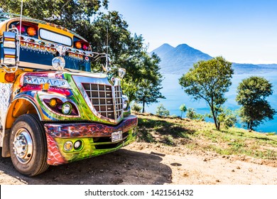 Lake Atitlan, Guatemala - November 10, 2018: Refurbished US school bus used as public bus called a camioneta with view of Lake Atitlan & volcanos in Guatemalan highlands.