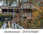 Lake cabin in the Alabama wilderness.  Rustic lake cabin at the top of hills in Alabama countryside. Blue railing and colorful leaves on trees.   