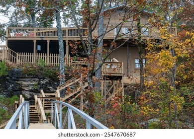 Lake cabin in the Alabama wilderness.  Rustic lake cabin at the top of hills in Alabama countryside. Blue railing and colorful leaves on trees.    - Powered by Shutterstock