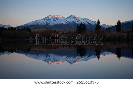 Lake Camp idyllic remote rural countryside early morning golden hour orange sky winter sunrise, Southern Alps mountain landscape at Ashburton Lakes Canterbury South Island New Zealand