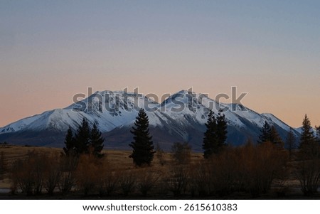 Lake Camp idyllic remote rural countryside early morning golden hour orange sky winter sunrise, Southern Alps mountain landscape at Ashburton Lakes Canterbury South Island New Zealand