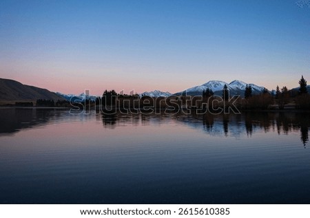 Lake Camp idyllic remote rural countryside early morning golden hour orange sky winter sunrise, Southern Alps mountain landscape at Ashburton Lakes Canterbury South Island New Zealand