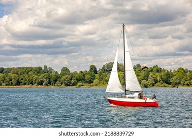 Lake Chiemsee, Bavaria, Germany - 10th June 2022: A german photographer visiting a lake in the bavarian alps during summer time. Sailing boat on the lake.