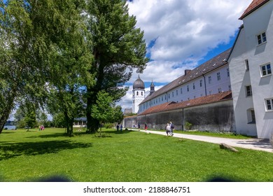 Lake Chiemsee, Bavaria, Germany - 10th June 2022: A german photographer visiting a lake in the bavarian alps during summer time. View across a meadow to the monastery Frauenchiemsee.