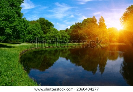 Lake in city park on blue sky background