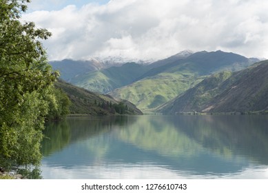 Lake Dustan On A Calm, But Cloudy Day, Surrounded By Snow Topped Hills. Central Otago, New Zealand.