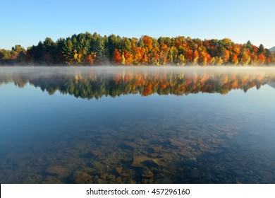 Lake fog with Autumn foliage and mountains with reflection in New England Stowe - Powered by Shutterstock