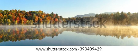 Lake fog panorama with Autumn foliage and mountains with reflection in New England Stowe