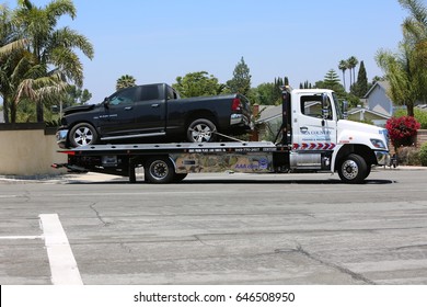 Lake Forest, California, May 23, 2017: A Flat Bed Tow Truck Removes And Halls Away A  Pool Service Truck After Causing An Accident Causing Hazmat To Respond And Clean Up Hazardous Chemicals.