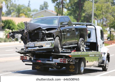 Lake Forest, California, May 23, 2017: A Flat Bed Tow Truck Removes And Halls Away A  Pool Service Truck After Causing An Accident Causing Hazmat To Respond And Clean Up Hazardous Chemicals.