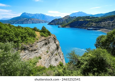 Lake of Serre-Ponçon in the French Alps, a dammed artificial reservoir gathering the water of the Durance river - Powered by Shutterstock