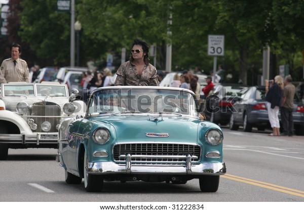 LAKE GEORGE, NY - MAY 30 : Elvis\
impersonators ride in the Elvis Classic Car Parade during the 2009\
Lake George Elvis Festival May 30, 2009 in Lake George,\
NY.