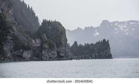 a lake with green cliffs under cloudy sky