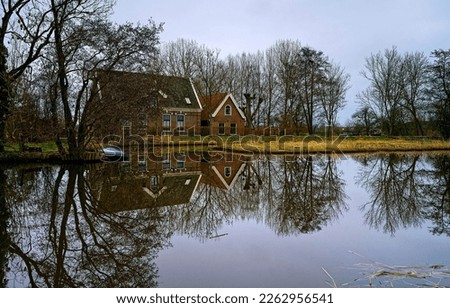 Lake house is reflected in pond water. Cottage by the pond. The cottage is reflected in the pond water. Lake house by the pond