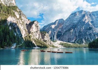 Lake Lago di Braies in Dolomiti mountains, South Tyrol, Italy. Dock with romantic old wooden rowing boats on lake. Amazing view of Lago di Braies (Braies lake, Pragser wildsee) in sunset light.