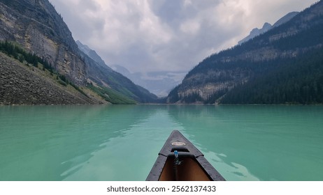 Lake Louise, Alberta, Canada - August 8 2023: Red canoe floating in turquoise water at Lake Louise. Couple canoeing together in the beautiful glacial Lake Louise at sunrise - Powered by Shutterstock