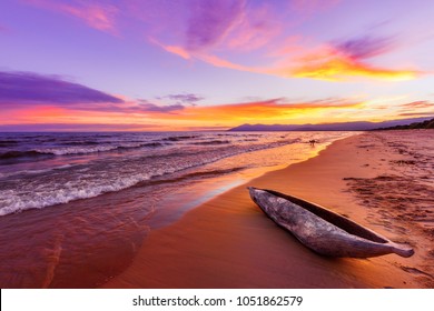 Lake Malawi sunset in Kande beach Africa, canoe boat on beach peaceful beach holiday beautiful sunset colors blue purple orange yellow in sky and clouds