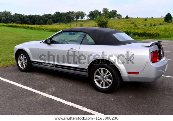 Lake Mills, Wisconsin / USA - August 27, 2018: 2005\
silver and black Ford Mustang Convertible with factory  spinners on\
the wheels. 